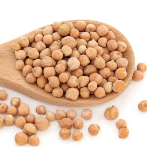 Chickpeas in a wooden spoon and scattered isolated over white background.